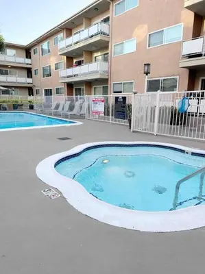 a swimming pool in front of a apartment building at Spacious South Bay Condo in Torrance