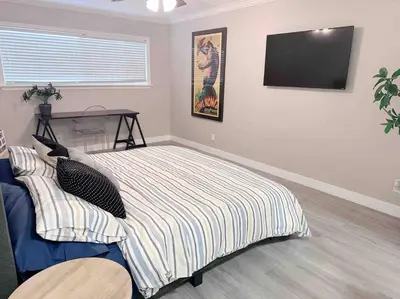a bedroom with a bed with a tv on the wall at Spacious South Bay Condo in Torrance