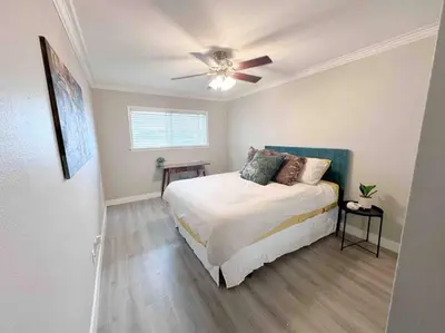 a bedroom with a bed and a ceiling fan at Spacious South Bay Condo in Torrance
