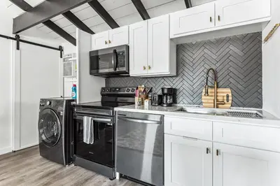 a kitchen with black appliances and white cabinets at Private Studio Oasis with Nature at Your Doorstep in Thousand Oaks