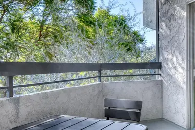 a table and a chair on a balcony with a window at Pasadena 1BR w gym pool nr Colorado Ave LAX-861 in Pasadena
