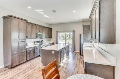 a kitchen with wooden cabinets and a counter top at Peaceful Riverside Home with Patio, 7 Mi to Downtown in Riverside