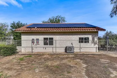 a small white house with solar panels on it at Peaceful Riverside Home with Patio, 7 Mi to Downtown in Riverside