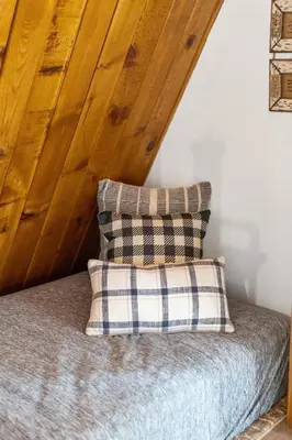 a bed with a pillow and a wooden ceiling at Cozy Cabin near Resorts and The Village +Mtn views in Big Bear City