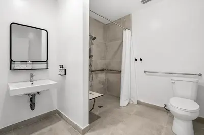 a bathroom with a toilet and a sink and a shower at Aliza Hotel in Los Angeles