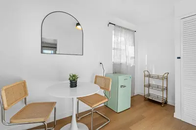 a dining room with a table and chairs and a refrigerator at Aliza Hotel in Los Angeles