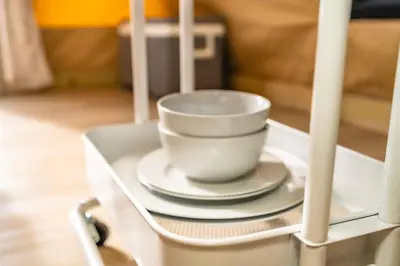 a white cup and saucer on a shelf in a cabinet at Glamping in the Urban in Glendora