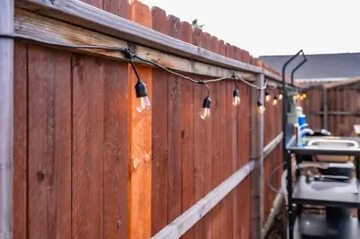 a fence with lights on the side of it at Glamping in the Urban in Glendora