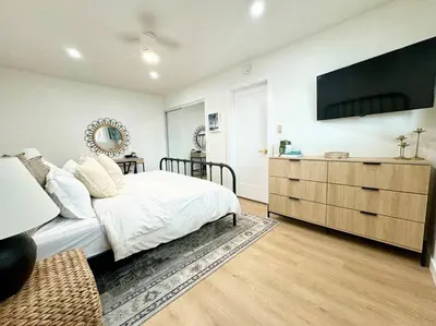 a bedroom with a bed and a television on the wall at SummerLillie #1 in Summerland