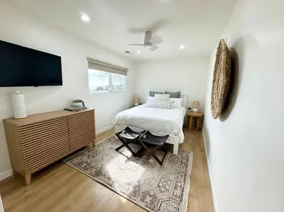 a bedroom with a bed and a flat screen tv at SummerLillie #1 in Summerland