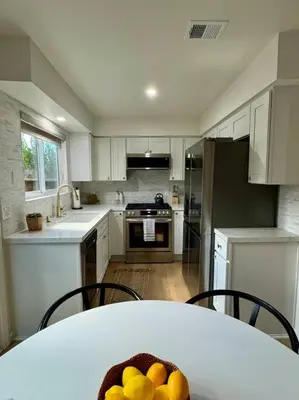 a kitchen with a table with a bowl of fruit on it at SummerLillie #1 in Summerland