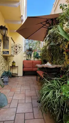 a patio with a couch and an umbrella at CASA LUX MONICA Prime Santa Monica Luxury Home ONE-OF-A-KIND in Los Angeles