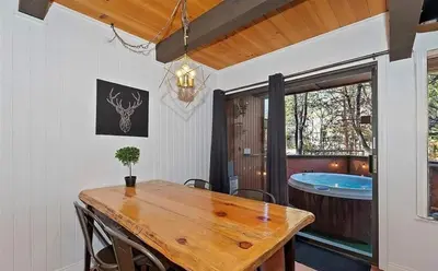 a dining room with a wooden table and a tub at Spa Steps to Lift Private Spa BBQ Massage Chair in Big Bear Lake