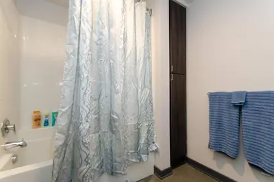 a bathroom with a shower curtain and a tub at Cozy 3bed Condo with balcony and a rooftop pool in Los Angeles