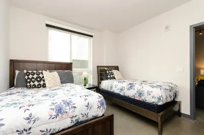 a bedroom with two beds and a window at Cozy 3bed Condo with balcony and a rooftop pool in Los Angeles