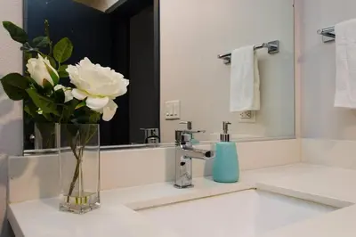 a bathroom with a vase of flowers on a sink at Cozy 3bed Condo with balcony and a rooftop pool in Los Angeles