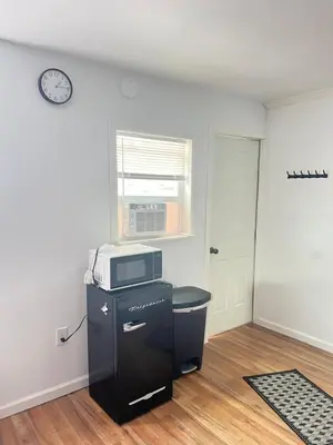 a room with a microwave on top of a refrigerator at LittleBetty's LandingPad in Torrance