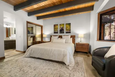 a bedroom with a large bed and a couch at Evergreen -LUXURY CABIN WITH A HOT TUB, GAME ROOM & 3 EN-SUITE BEDROOMS! in Big Bear Lake