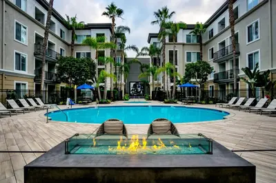 a swimming pool with two lounge chairs in front of a building at Luxe Marina Del Rey Apartment,Parking, Gym, Pool, jacuzzi,BBQ in Los Angeles