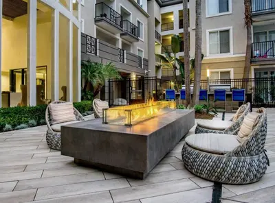 a patio with chairs and a table in front of a building at Luxe Marina Del Rey Apartment,Parking, Gym, Pool, jacuzzi,BBQ in Los Angeles
