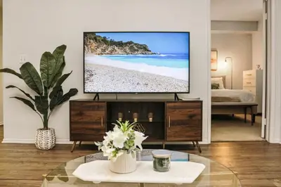 a living room with a flat screen tv on a wall at Luxe Marina Del Rey Apartment,Parking, Gym, Pool, jacuzzi,BBQ in Los Angeles