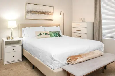 a bedroom with a large white bed with a bench at Luxe Marina Del Rey Apartment,Parking, Gym, Pool, jacuzzi,BBQ in Los Angeles
