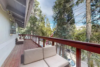 a balcony with a white couch and trees at Idyllic Cabin in the Woods Cozy Crestline Retreat in Arrowhead Highlands