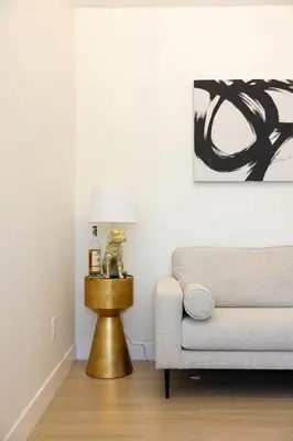 a living room with a gold lamp and a couch at Hollywood Family Nest in Burbank, Steps to Studios! in Burbank