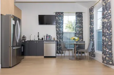 a kitchen and dining room with a table and a refrigerator at Hollywood Family Nest in Burbank, Steps to Studios! in Burbank