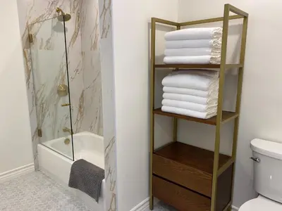 a bathroom with a shower and a rack of towels at Guest house with private entry and large pool in Los Angeles