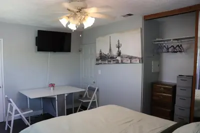 a bedroom with a bed and a table and a table at Private Room with Laundry and Pool access in Riverside