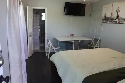 a bedroom with a bed and a table with chairs at Private Room with Laundry and Pool access in Riverside