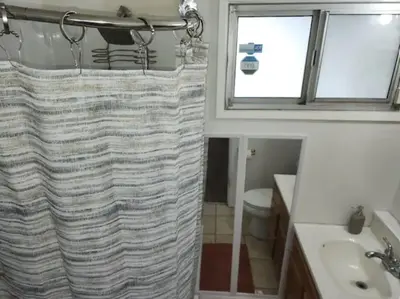 a bathroom with a shower curtain and a sink at Private Room with Laundry and Pool access in Riverside