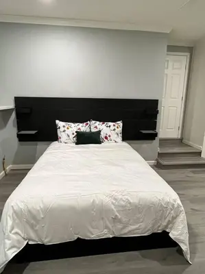 a bedroom with a large white bed with a black headboard at Lux Cozy Experience Elegance in San Bernardino