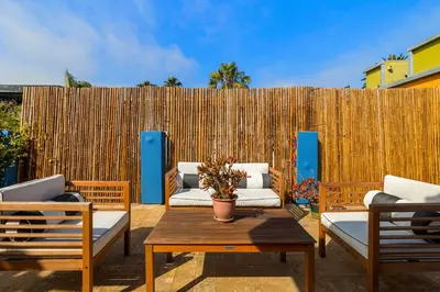 a patio with couches and a table and a fence at Artsy Venice Beach Canals Studio w/Rooftop & Sauna in Los Angeles