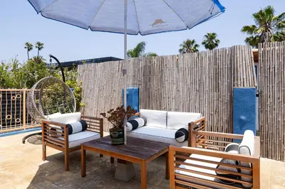 a patio with two chairs and a table with an umbrella at Artsy Venice Beach Canals Studio w/Rooftop & Sauna in Los Angeles
