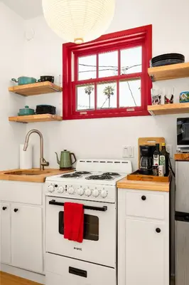 a kitchen with a white stove and a red window at Artsy Venice Beach Canals Studio w/Rooftop & Sauna in Los Angeles
