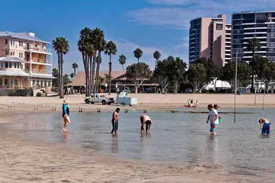 a group of people standing in the water at the beach at Luxury ApartStudio Marina Del Rey Pool, Gym, Parking, Jacuzzi, BBQ in Los Angeles