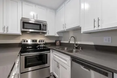 a kitchen with white cabinets and a stove and a microwave at Hollywood 1BR w pool nr Griffith Park trails LAX-117 in Los Angeles