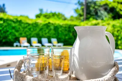 a white vase and some glasses on a table at Sophia's Oasis in Los Angeles
