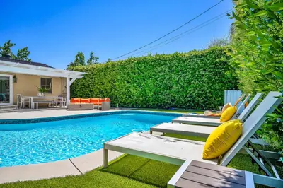 a swimming pool with two chairs next to a house at Sophia's Oasis in Los Angeles