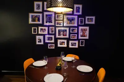 a wooden table with chairs and plates and photos on a wall at Downtown LA - Mamba Suite - Free Indoor Parking! in Los Angeles