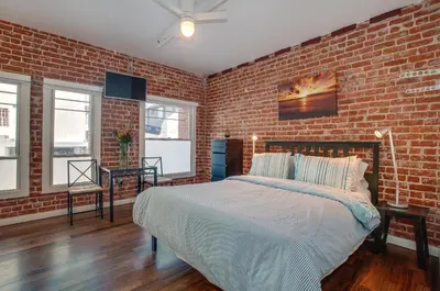 a bedroom with a brick wall and a bed at Venice Breeze Suites in Los Angeles