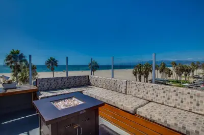 a couch on a balcony with a view of the beach at Venice Breeze Suites in Los Angeles