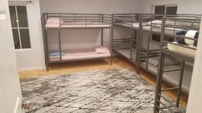 a room with three bunk beds with a rug at Rumi in Los Angeles