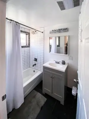 a white bathroom with a tub and a sink and a bath tub at Rumi in Los Angeles