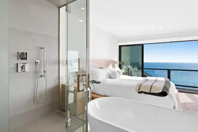 a bathroom with a shower and a tub and a bedroom at Aquazzura - By Stay Awhile Villas in Malibu