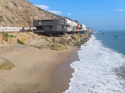a house on a cliff next to the beach at Aquazzura - By Stay Awhile Villas in Malibu