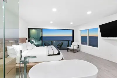 a bedroom with a bed and a view of the ocean at Aquazzura - By Stay Awhile Villas in Malibu