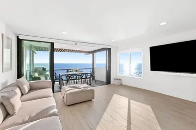 a living room with a couch and a flat screen tv at Aquazzura - By Stay Awhile Villas in Malibu
